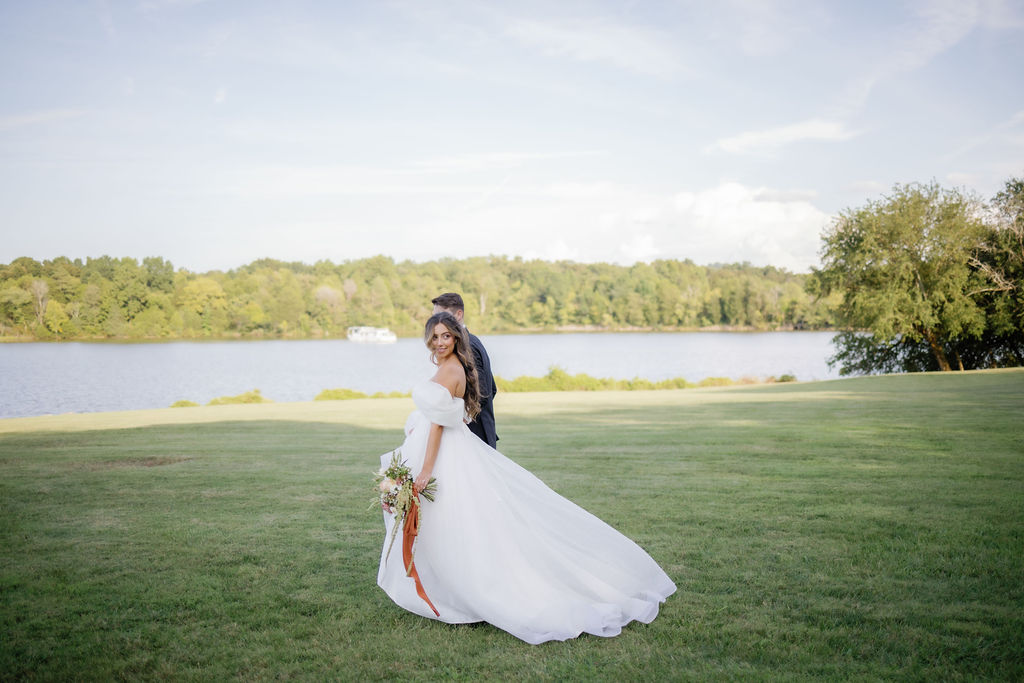 Gatlinburg elopement at Marblegate Farm with bride and groom walking through a field together towards a lake