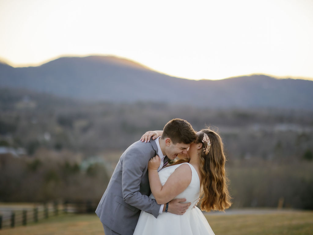 candid wedding photos with groom laughing as he hugs his bride on a hill top at Harpers Vineyard Townsend TN