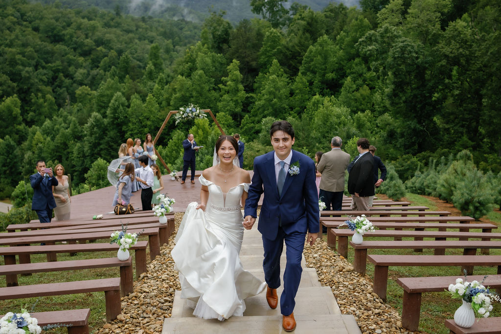 bride and groom holding hands and exiting their outdoor ceremony at Mountain Mist Famrs