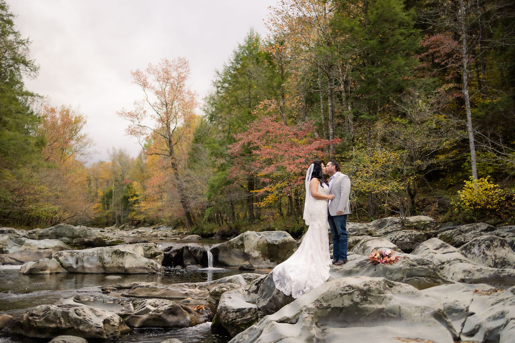 fall elopement in the mountains with bride and groom kissing in the woods for bridal portraits with photographers in gatlinburg tn for their Smoky Mountain elopement