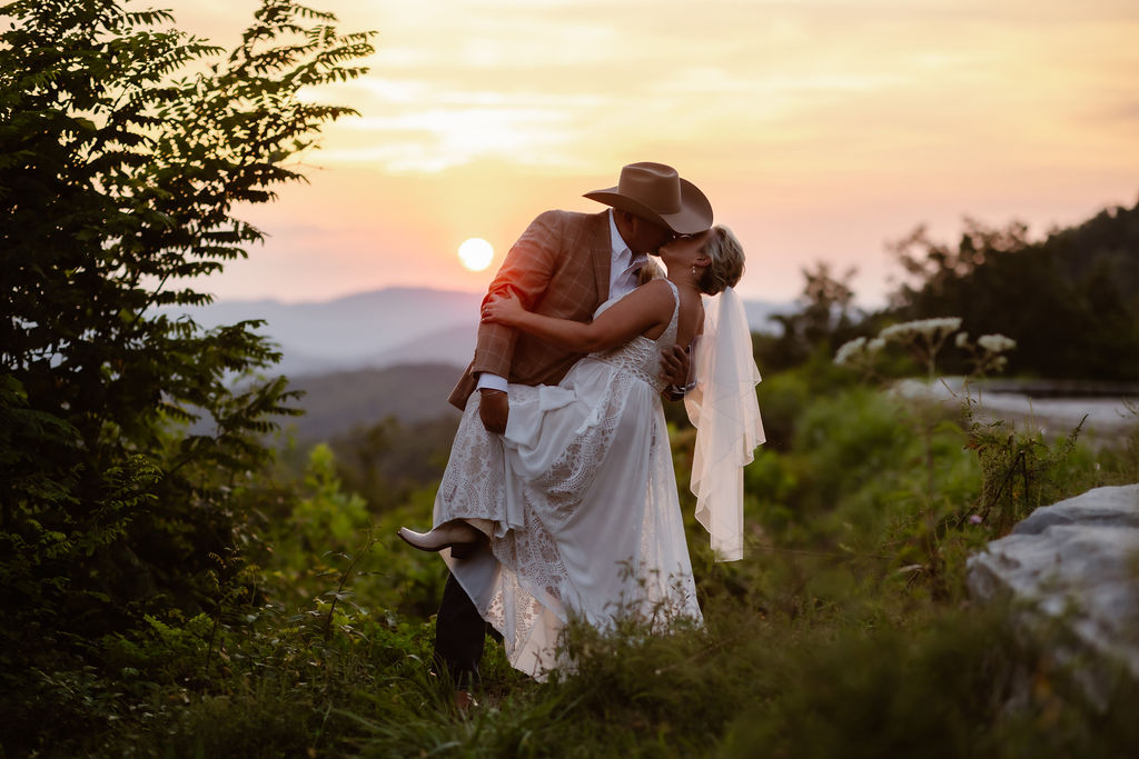Foothills Parkways elopement with couple kissing passionately with a deep sunset behind they making the smoky mountains glow
