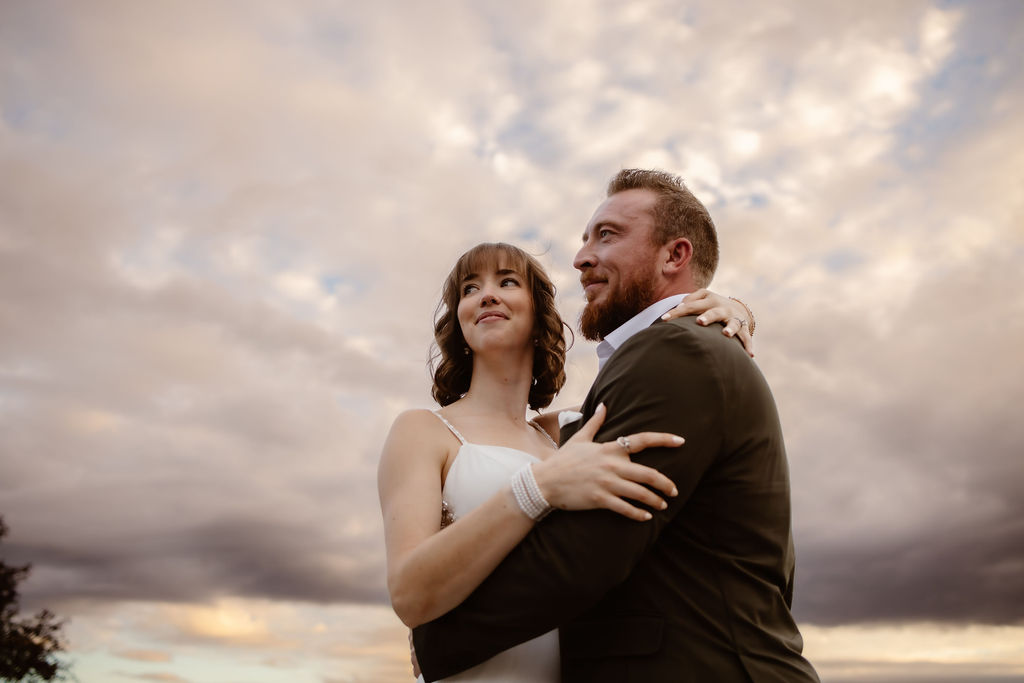 Wrapped in each other’s arms beneath a dramatic sky, this couple radiates joy during their Gatlinburg elopement in the foothills, where love meets the clouds and mountain magic begins.