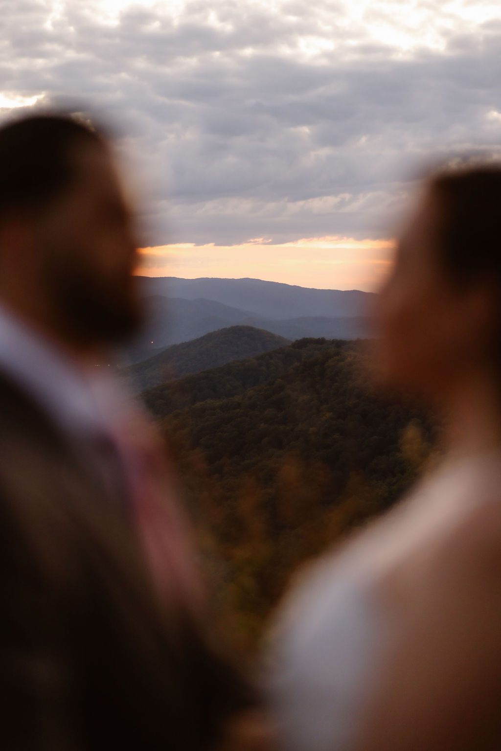 Blurred silhouettes of a bride and groom framing a scenic mountain landscape at sunset, emphasizing the Foothills Parkway location during a Gatlinburg elopement by a Gatlinburg wedding photographer