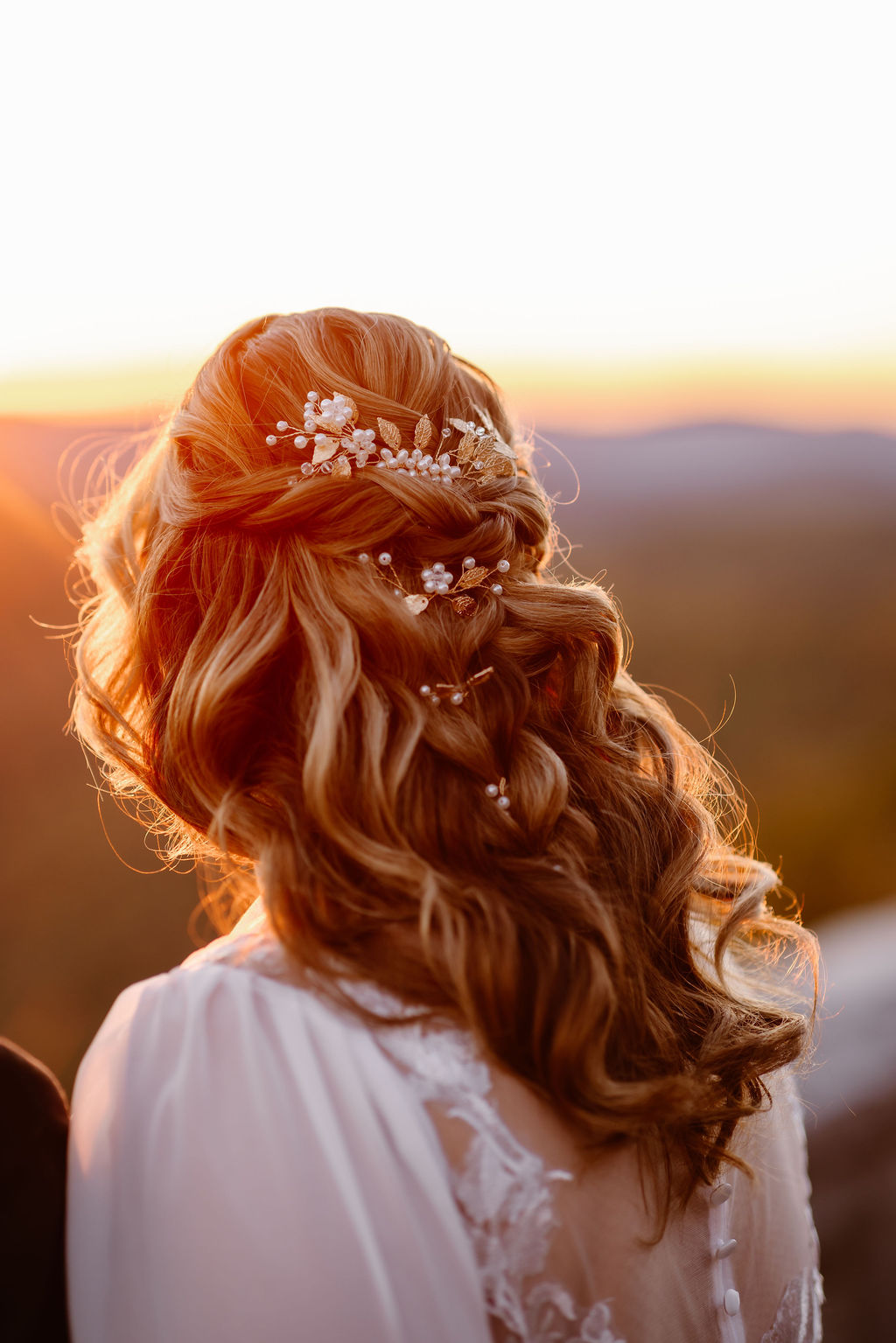 Half-up bridesmaid hair with soft curls and pearl hair pins, styled for a Gatlinburg elopement at sunset overlooking mountain scenery