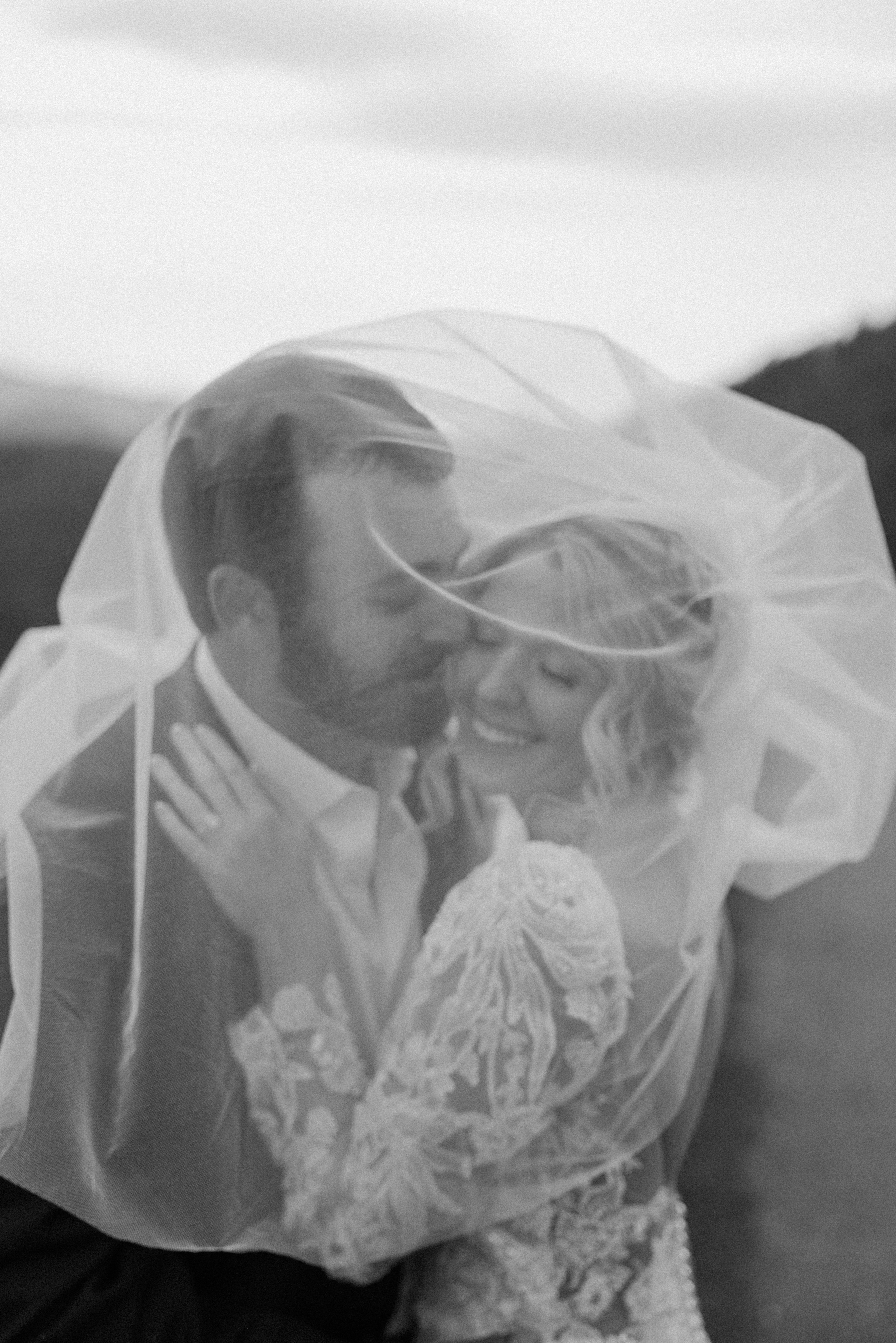 Black and white portrait of bride and groom under a flowing veil during their Smoky Mountain wedding