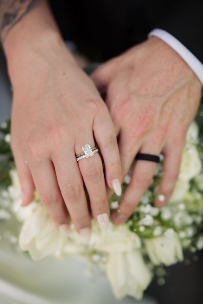 Close-up of the newlyweds’ wedding rings resting over a white floral bouquet following their Gatlinburg elopement.