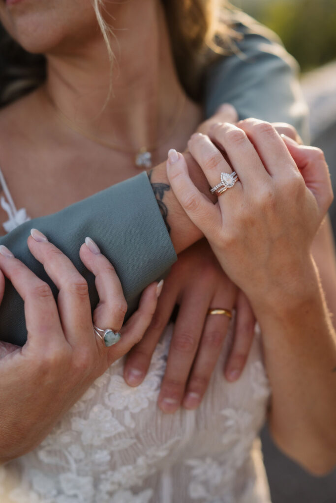 Close-up of the bride’s wedding rings and the couple’s hands, photographed in warm evening light by their Gatlinburg wedding photographer.