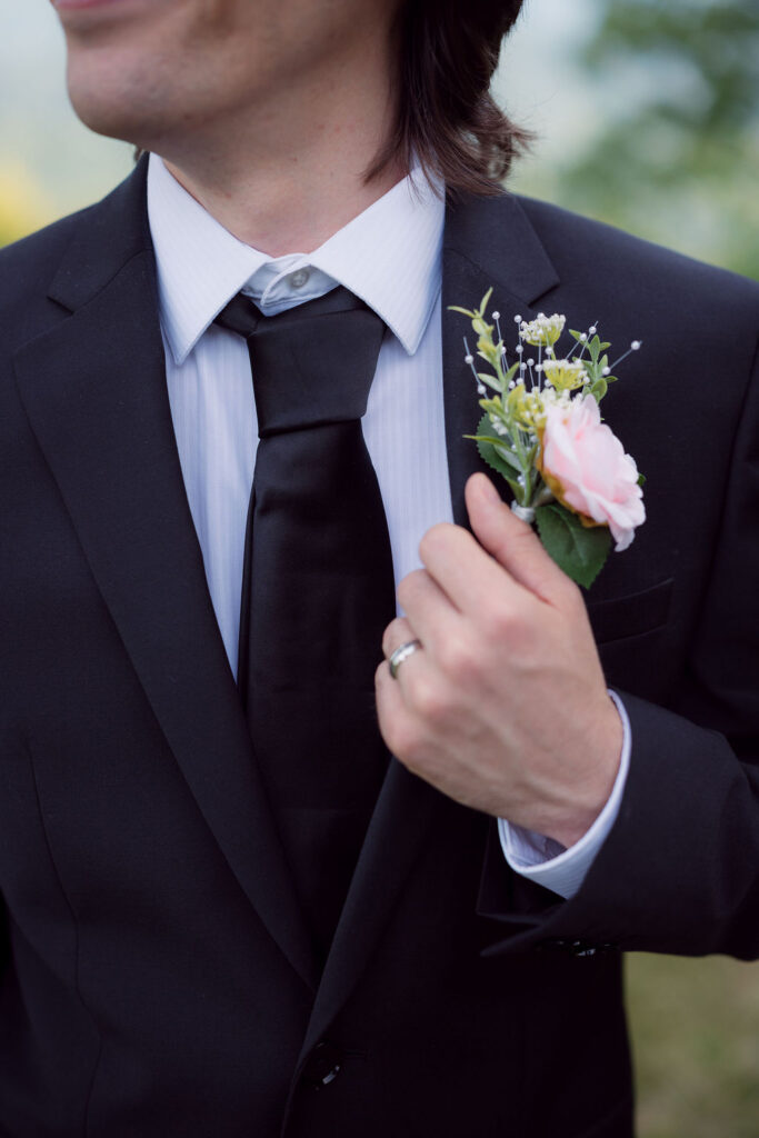 Close-up of the groom’s pink floral boutonniere and black suit, a detail captured during a Gatlinburg elopement.