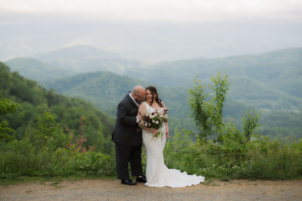 Bride and groom share a quiet embrace with panoramic mountain views along Foothills Parkway, capturing the romance and natural beauty of eloping to Gatlinburg.