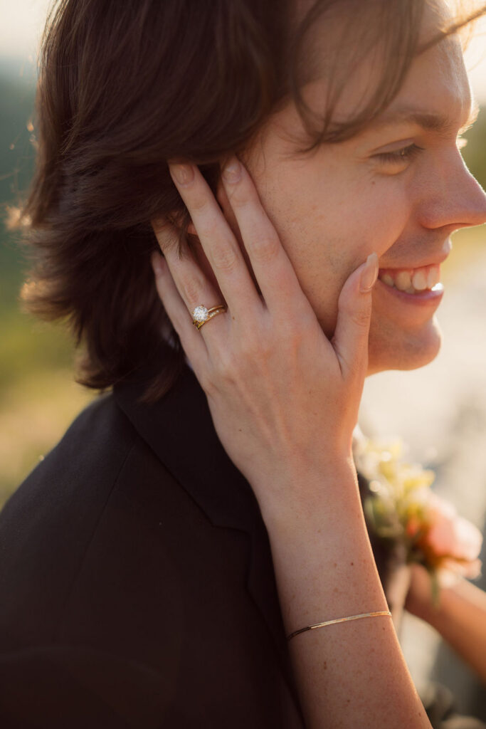 Close-up of the bride’s wedding rings as she touches the groom’s face, a detail captured during their Gatlinburg elopement.
