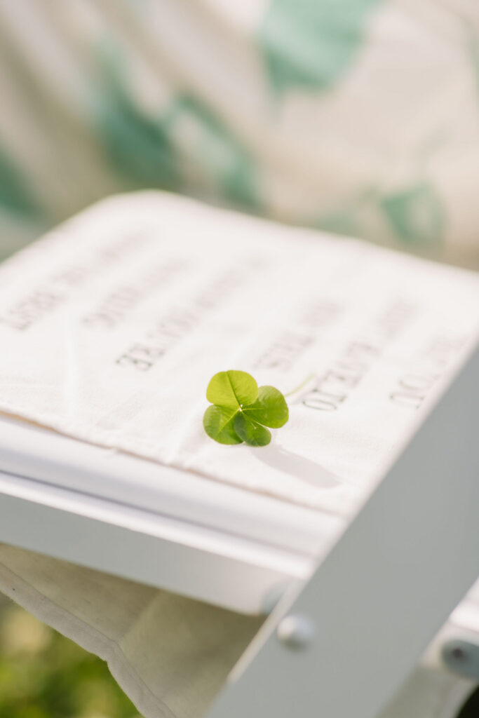 Four-leaf clover rests on a wedding ceremony program, a small detail captured by a Gatlinburg wedding photographer during a mountain celebration.