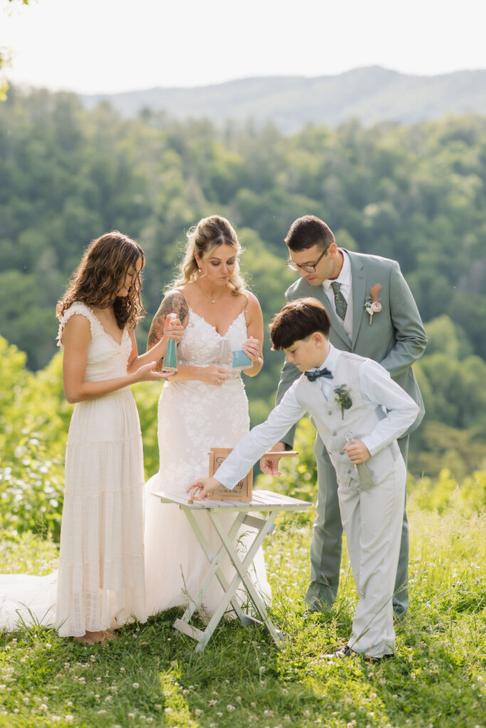 Bride, groom, and two young attendants gather for a family unity ritual during their intimate Gatlinburg elopement in the Smoky Mountains.