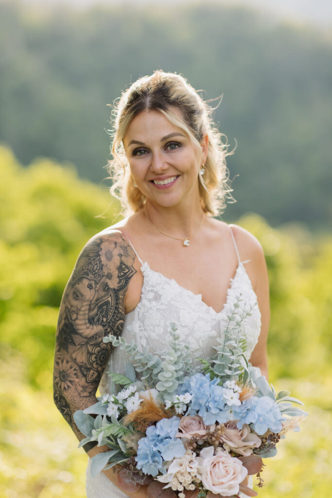 Bridal portrait with blue and blush flowers and a mountain backdrop, photographed during an intimate Gatlinburg elopement.