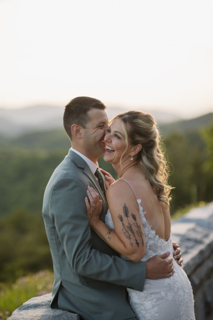 Bride and groom laugh together during sunset portraits, with soft Smoky Mountain views creating a natural backdrop for their Gatlinburg wedding photographer.