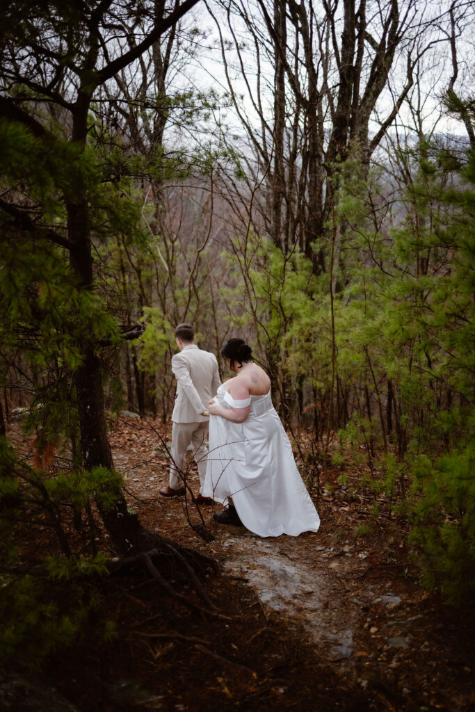 Newlyweds hike through a forest trail after eloping to Gatlinburg at foothills parkway, capturing the adventurous spirit of their wedding day.