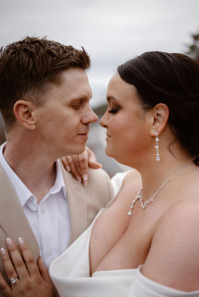 Close-up portrait of newlyweds embracing after eloping to Gatlinburg and foothills parkway, highlighting their wedding attire, rings, and joyful expressions.