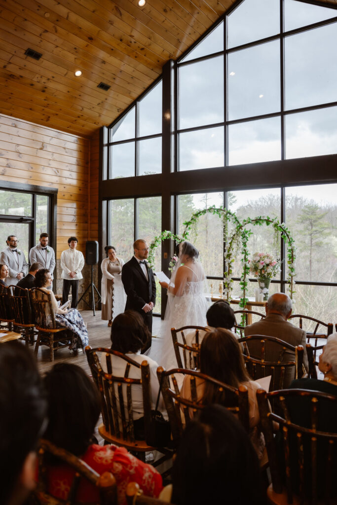 Guests gather inside the ceremony space as the couple exchanges vows during their Wild Briar Lodge Wedding, highlighting the beauty of eloping to Gatlinburg with loved ones.
