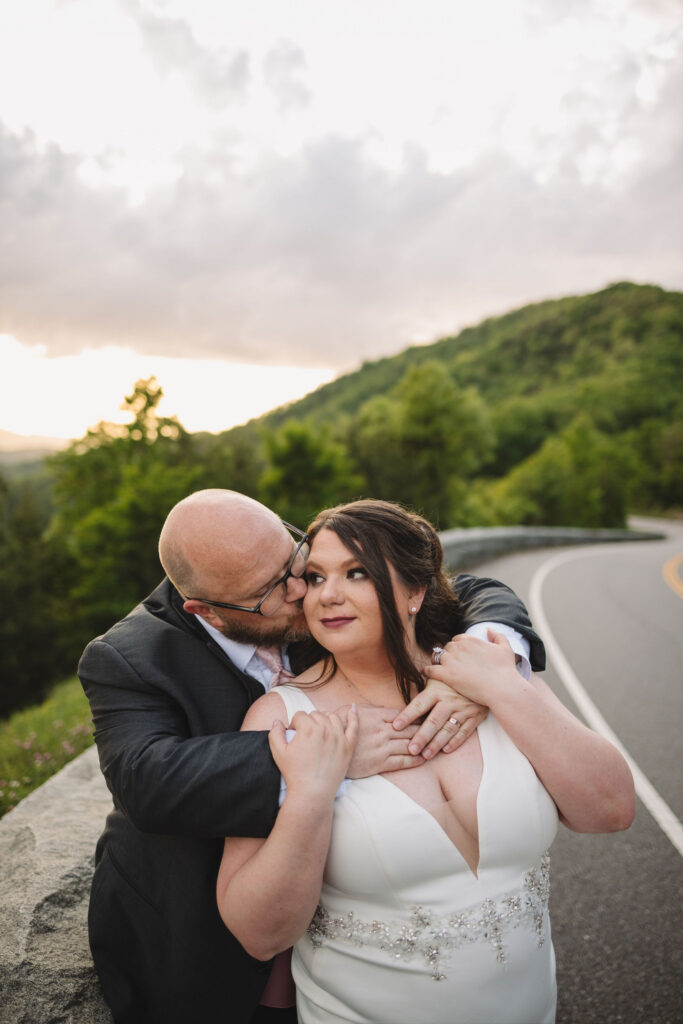 Couple sharing a quiet embrace along Foothills Parkway at sunset, highlighting the romance of eloping to Gatlinburg with mountain views in the background.