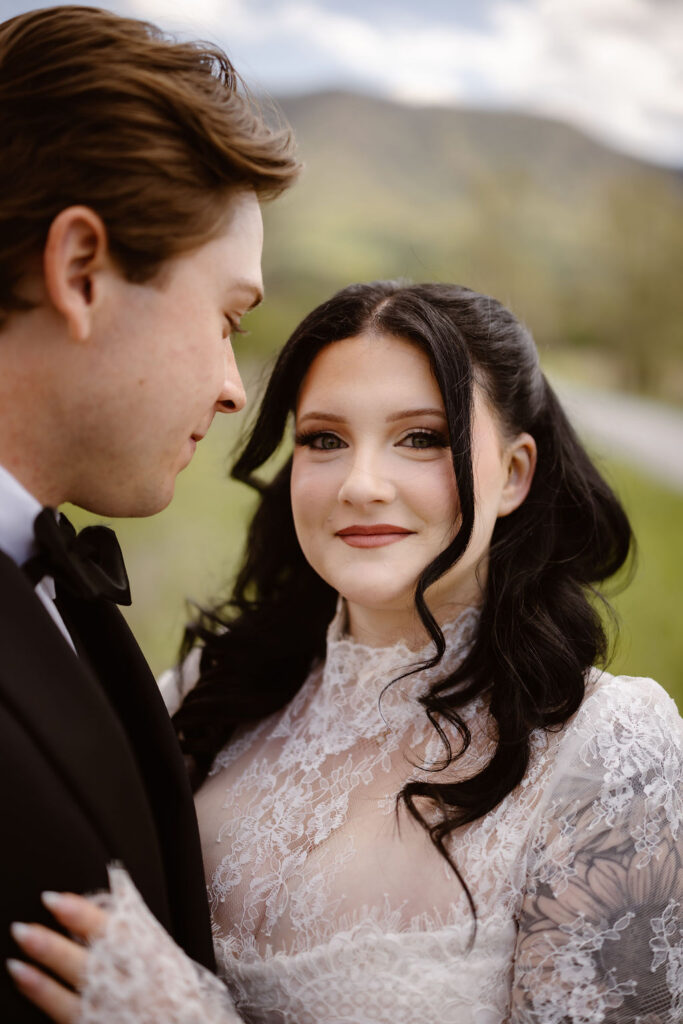 Close-up portrait of a bride and groom in Cades Cove with mountain scenery in the background, capturing a romantic moment while eloping to Gatlinburg.