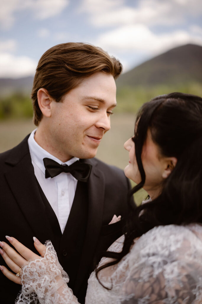 Bride and groom share a quiet moment in Cades Cove with the Smoky Mountains in the background, capturing the intimacy of eloping to Gatlinburg.