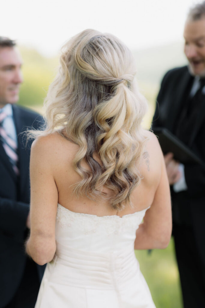 Close-up of the bride’s half-up curled wedding hairstyle during an outdoor ceremony, captured by a gatlinburg photographer while eloping to gatlinburg.
