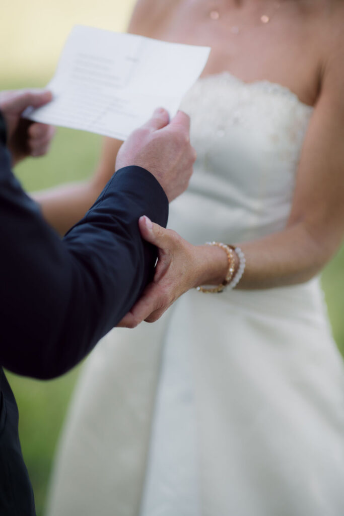 Close-up of a groom reading handwritten vows while holding his bride’s hand during their Gatlinburg Elopement Ceremony.
