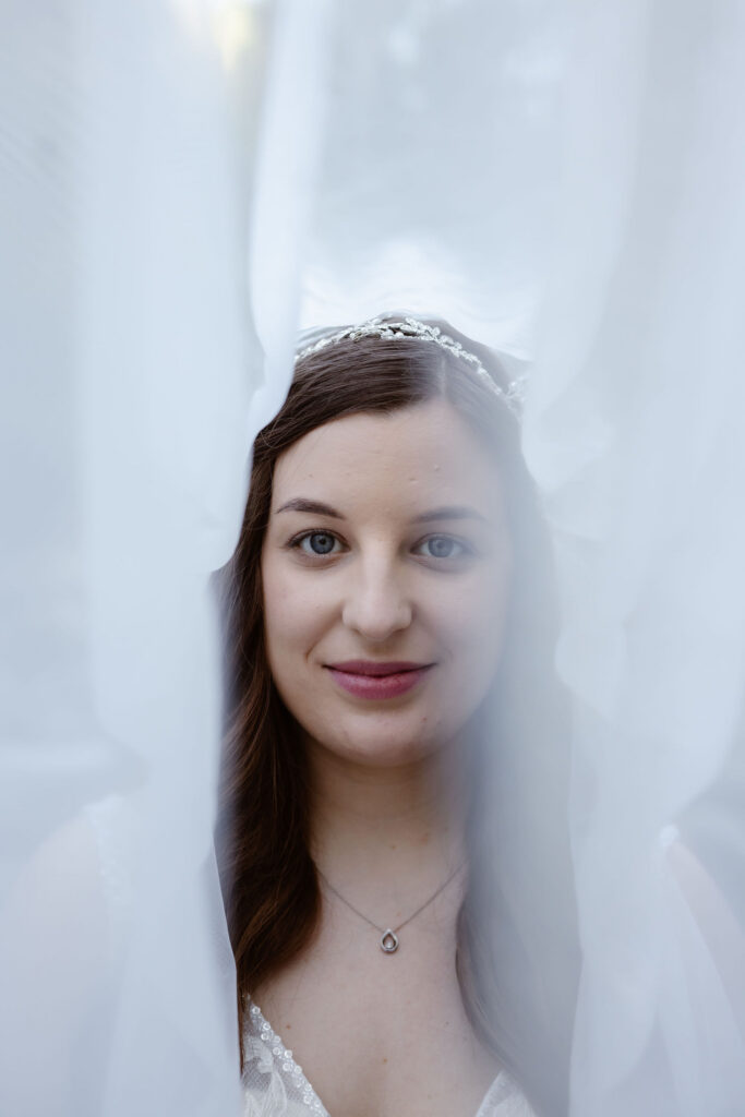 Close-up bridal portrait framed through her sheer veil, photographed during an intimate wedding day while eloping to gatlinburg.