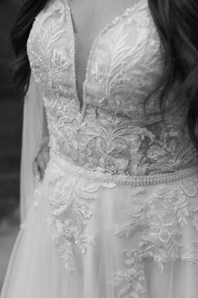 Black-and-white close-up of intricate lace, floral embroidery, and beading on a wedding dress worn while eloping to gatlinburg.