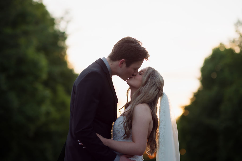 Bride and groom sharing a sunset kiss surrounded by trees during their romantic Gatlinburg elopement photography session.